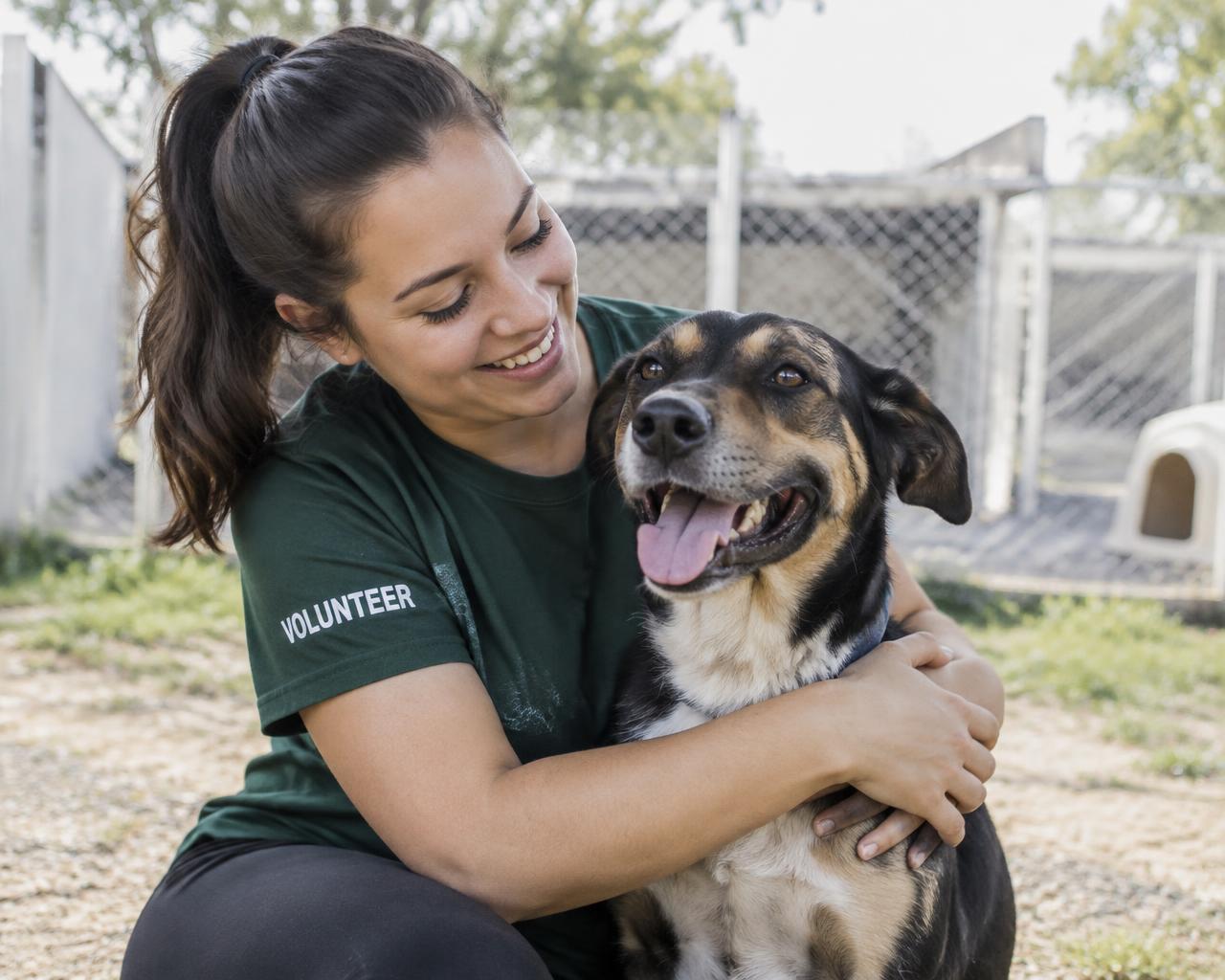 Volunteer hugging a rescued dog